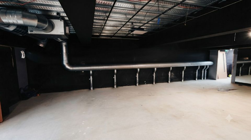 Exposed spiral extract carried the full length of the wall on matched brackets at Infinity Fitness, Sittingbourne. In a gym the ductwork is part of the interior.